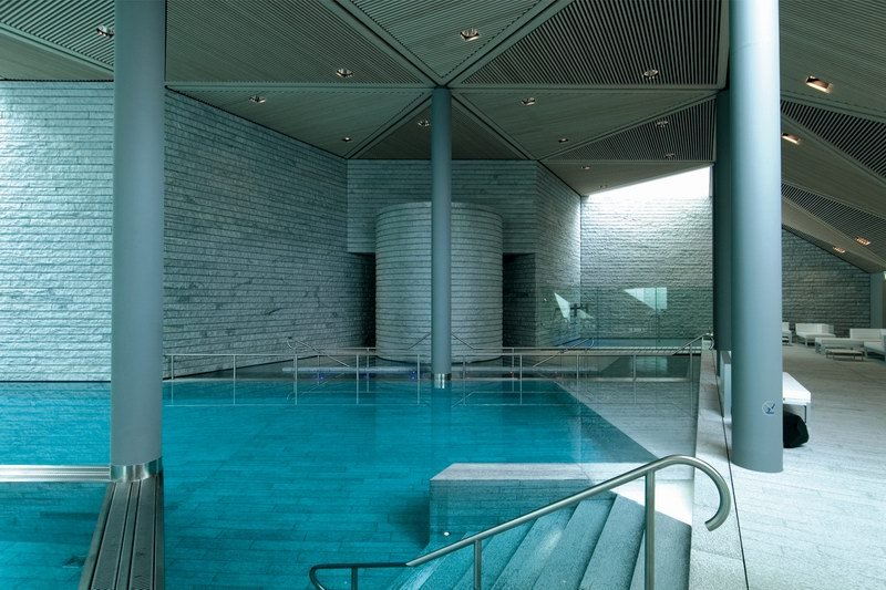 用加拿大枫木铺设成三角形的天花除了装饰作用外还是温泉内完美声学设计的重要构成之一。灰色的条形石板铺设 ...