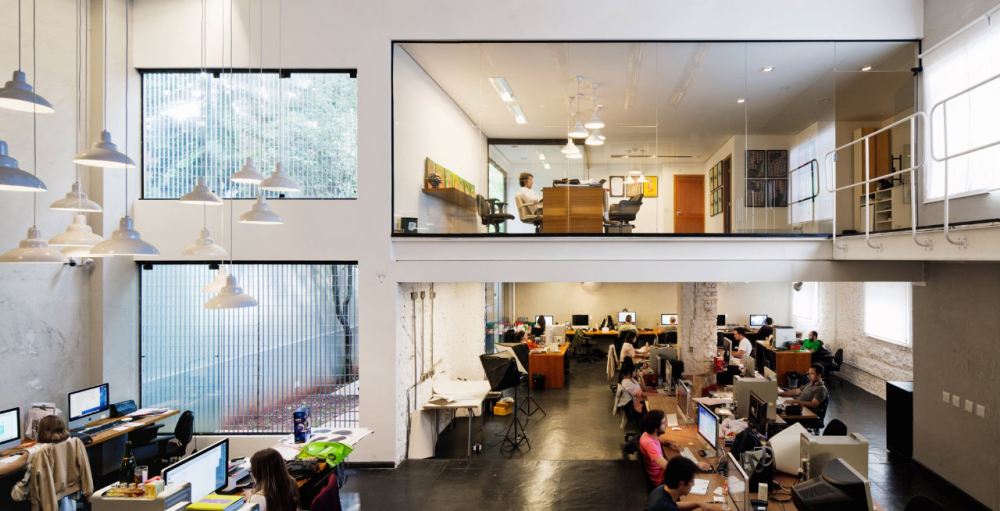 老建筑时尚变身 Casa Rex office跨越世纪的办公室_工作区域是一个两层楼挑高的开放性空间
