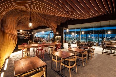 OOZN Design creates cavernous cafe in Jakarta using undulating timber slats_6-Degrees-Cafe-in-Indonesia-by-OOZN-Design_dezeen_9.jpg