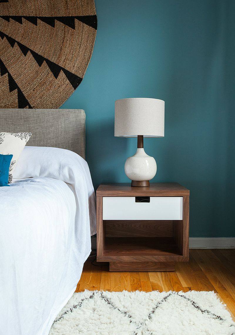 泽西市的LOFT公寓_Walnut-bedside-table-and-table-lamp-give-the-contemporary-bedroom-a-midcentury-vibe.jpg