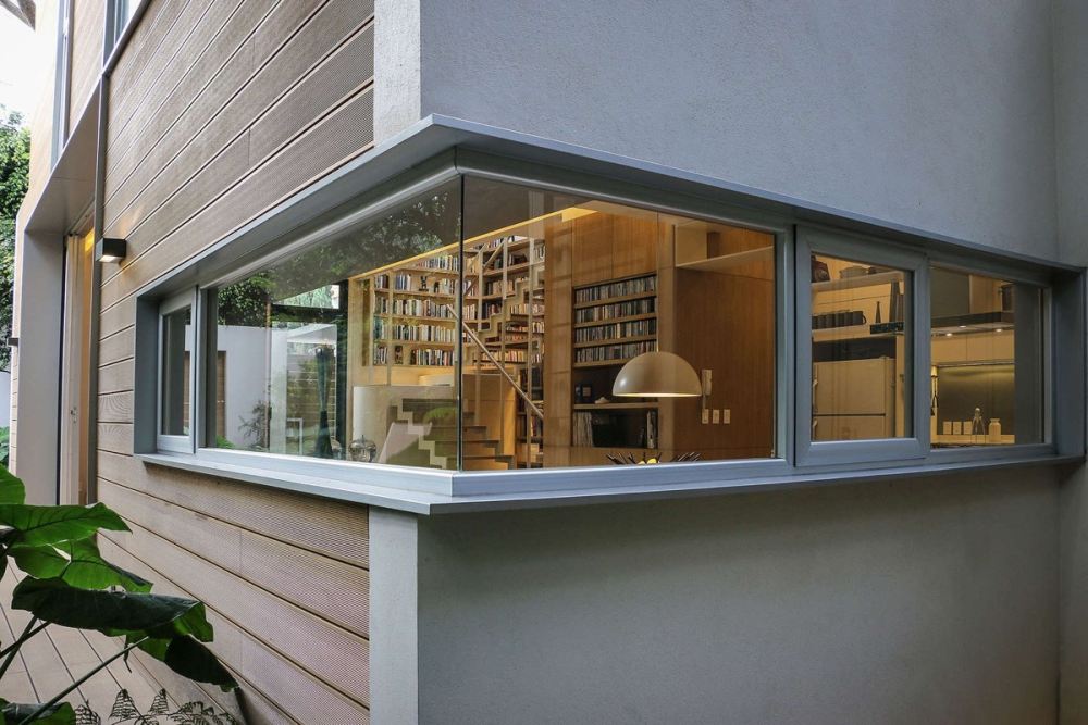 A Book Lover’s Dream House With Great Nature Views_window-across-wood-and-plaster-timber-home.jpg